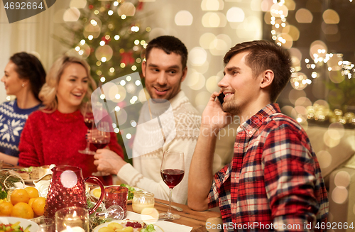 Image of man calling on smartphone at christmas dinner