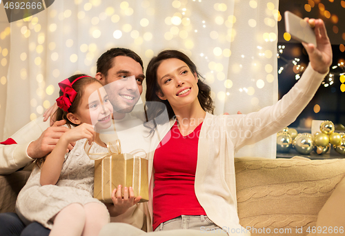 Image of happy family with christmas present at home