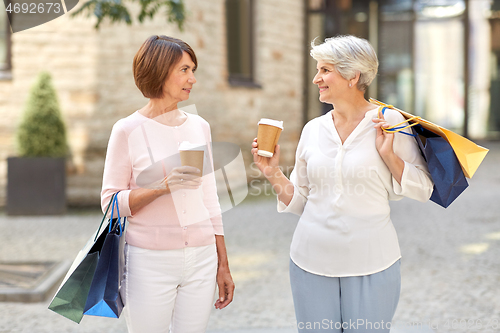 Image of senior women with shopping bags and coffee in city