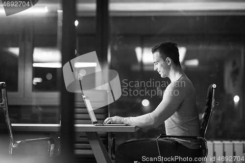 Image of man working on laptop in dark office