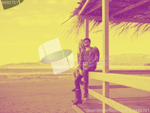 Image of young couple drinking beer together at the beach