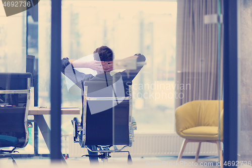 Image of young businessman relaxing at the desk