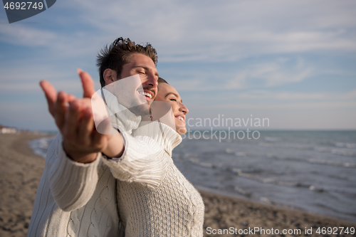 Image of Loving young couple on a beach at autumn sunny day