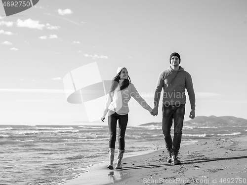 Image of Loving young couple on a beach at autumn sunny day