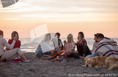 Image of Friends having fun at beach on autumn day