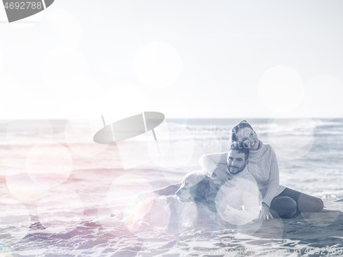 Image of Couple with dog enjoying time on beach