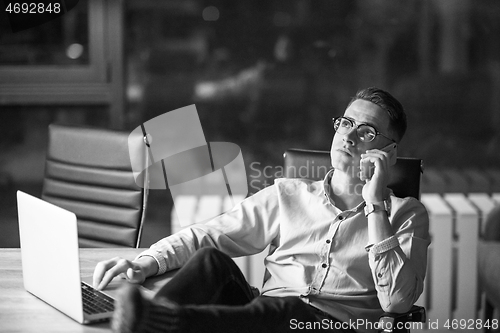 Image of businessman using mobile phone in dark office