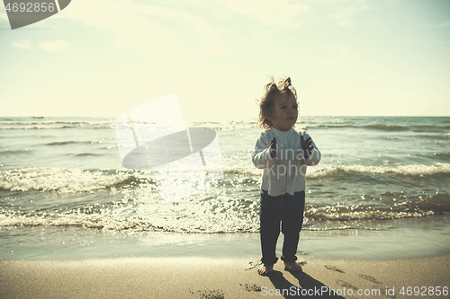 Image of cute little girl at autumn beach