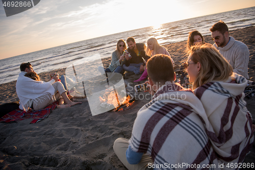 Image of Friends having fun at beach on autumn day