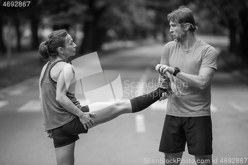 Image of runners team warming up and stretching before morning training