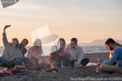 Image of Friends having fun at beach on autumn day