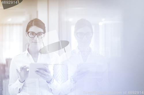 Image of Business Woman Using Digital Tablet in front of startup Office