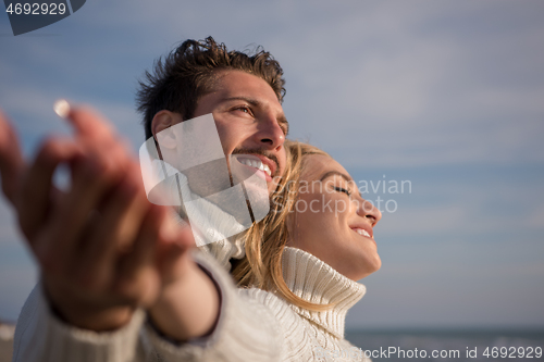 Image of Loving young couple on a beach at autumn sunny day