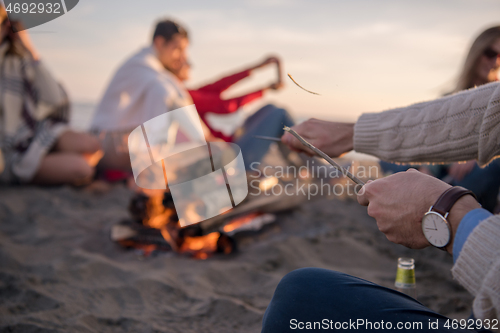 Image of Friends having fun at beach on autumn day