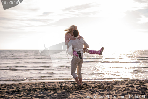 Image of Loving young couple on a beach at autumn sunny day