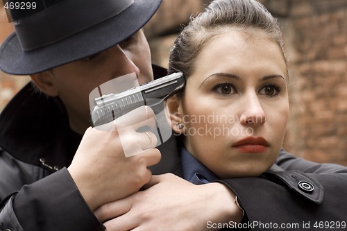 Image of man threatens the woman with a pistol