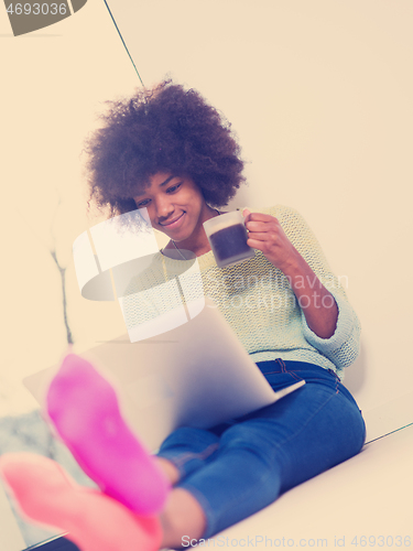 Image of black woman in the living room on the floor