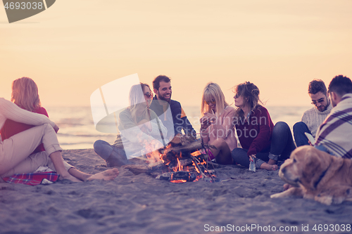 Image of Friends having fun at beach on autumn day