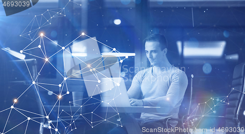 Image of man working on laptop in dark office