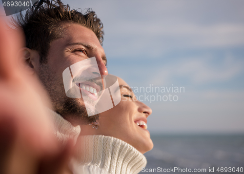 Image of Loving young couple on a beach at autumn sunny day