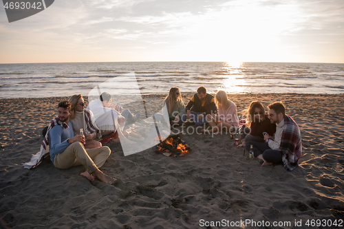 Image of Friends having fun at beach on autumn day