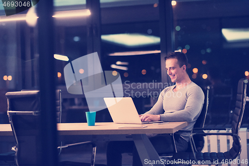 Image of man working on laptop in dark office