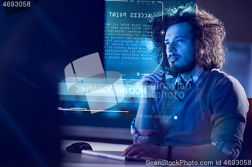 Image of man working on computer in dark office