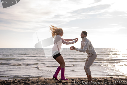 Image of Loving young couple on a beach at autumn sunny day