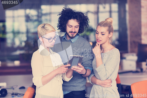 Image of group of Business People Working With Tablet in startup office