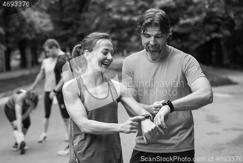 Image of sporty couple using smart watches