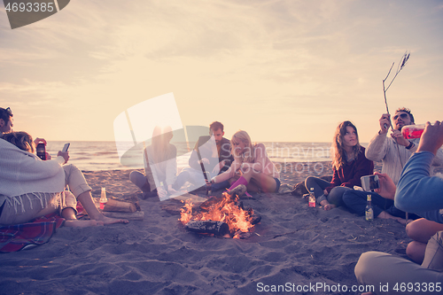 Image of Friends having fun at beach on autumn day