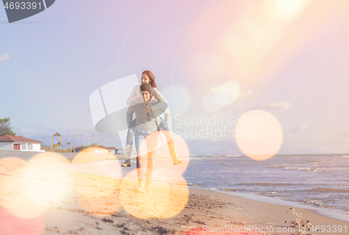 Image of couple having fun at beach during autumn