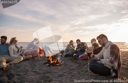 Image of Friends having fun at beach on autumn day