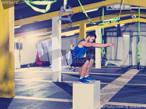 Image of man working out jumping on fit box