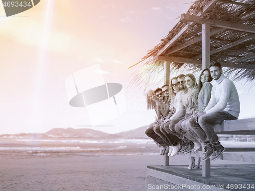 Image of Group of friends having fun on autumn day at beach