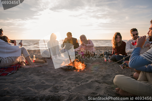 Image of Friends having fun at beach on autumn day