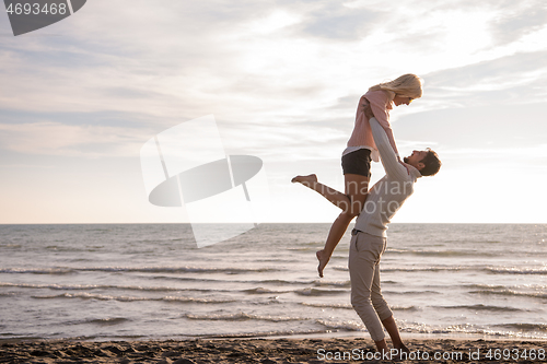 Image of Loving young couple on a beach at autumn sunny day