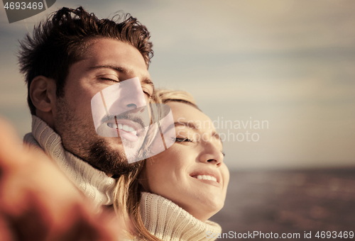 Image of Loving young couple on a beach at autumn sunny day