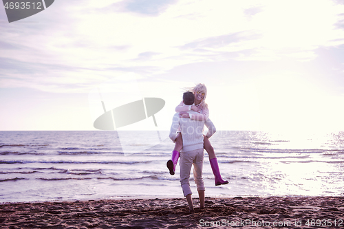 Image of Loving young couple on a beach at autumn sunny day