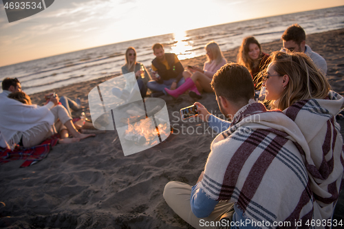 Image of Friends having fun at beach on autumn day