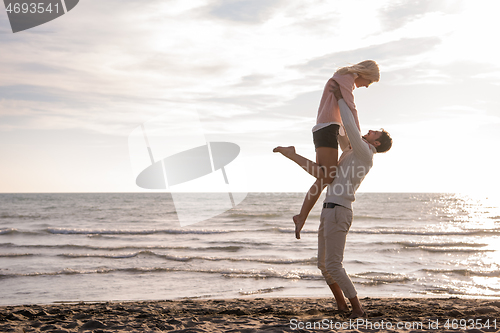 Image of Loving young couple on a beach at autumn sunny day