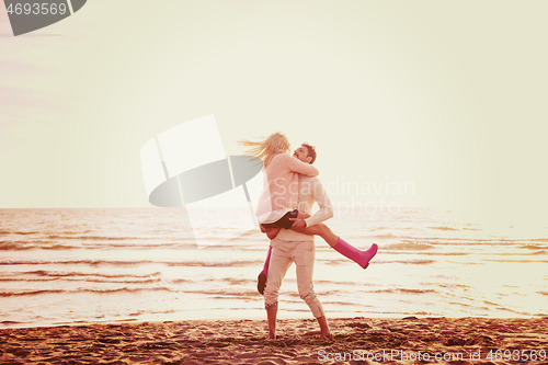 Image of Loving young couple on a beach at autumn sunny day