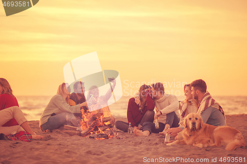 Image of Friends having fun at beach on autumn day