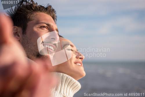 Image of Loving young couple on a beach at autumn sunny day