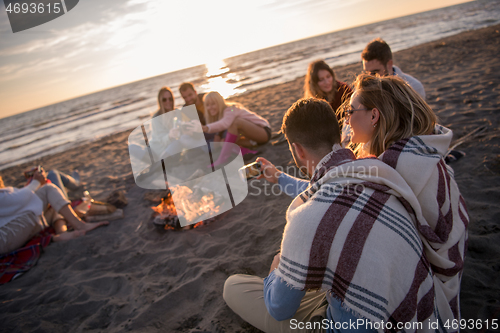 Image of Friends having fun at beach on autumn day