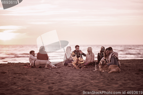 Image of Friends having fun at beach on autumn day