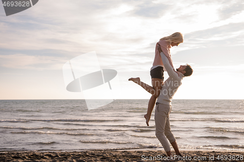 Image of Loving young couple on a beach at autumn sunny day