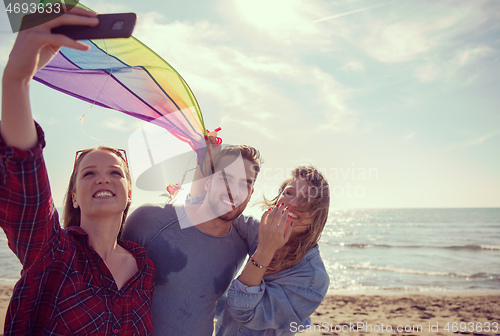 Image of Group of friends making selfie on beach during autumn day