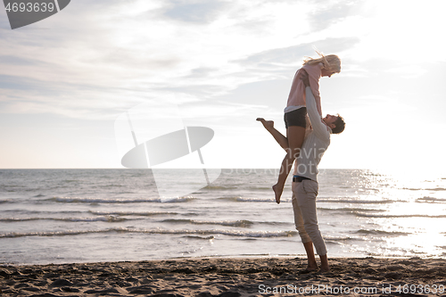 Image of Loving young couple on a beach at autumn sunny day