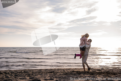 Image of Loving young couple on a beach at autumn sunny day